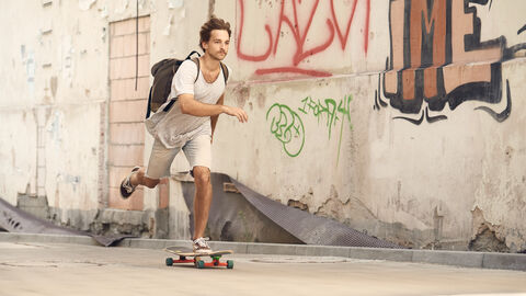 Mann unterwegs auf Skateboard
