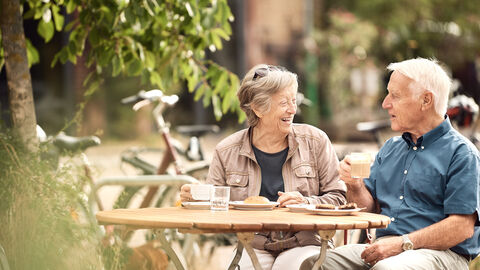 Älteres Paar sitzt gemütlich zusammen bei Fahrradausflug