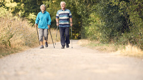 Älteres Paar unterwegs mit Wanderstöcken