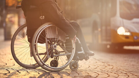 Rollstuhlfahrer wartetn auf Bus