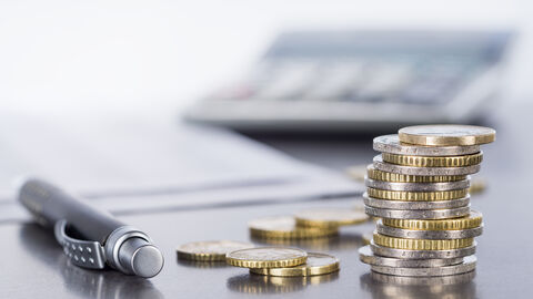 Geld Geldmünzen vor Taschenrechner