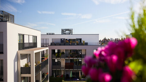 Blick vom Balkon in einer Neubausiedlung auf andere Neubauten