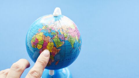 Finger tippt auf Mini-Globus