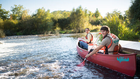 Zwei Personen fahren mit dem Kanu auf der Lahn
