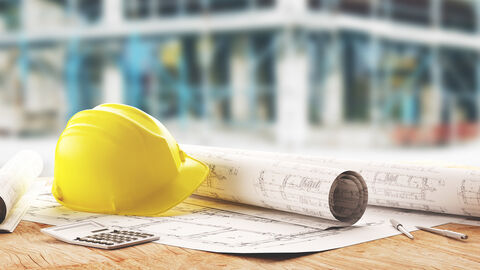 Architekturpläne und Bauhelm 