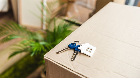 Hausschlüssel liegt auf Umzugskarton
