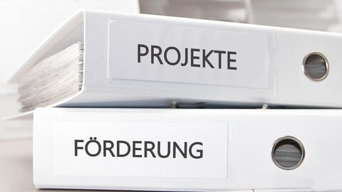 Förderung von Projekten und Unternehmen Zwei Ornder mit dem Namen Projekte und Förderung liegen übereinander