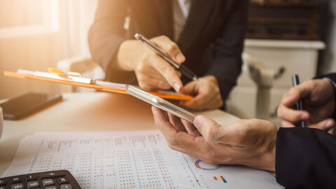 Zwei Personen besprechen Statistiken und Berechnungen