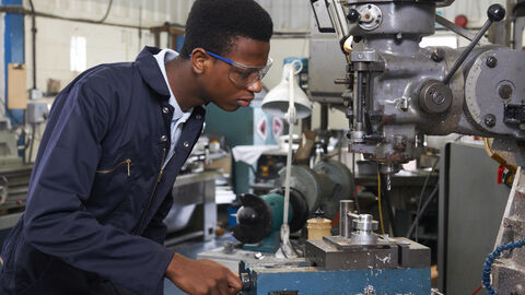 Auszubildender bedient Maschine