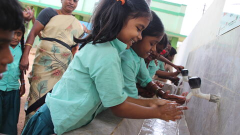 Kinder freuen sich über neu erbaute Anlage zur Trinkwasserversorgung und zum Händewaschen Spielerisch erlernen die Kinder Hygieneverhalten