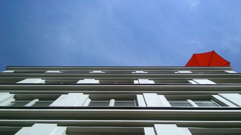 Mehrstöckiges Mietshaus mit Sonnenschirm auf dem Dach