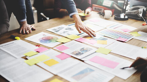 Entwürfe liegen auf einem Tisch und werden besprochen