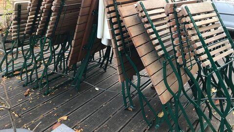 Geschlossenen Außengastronomie Zusammengeklappte Tische und Stühle in der Außengastronomie