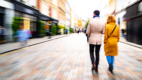 Mann und Frau spazieren durch eine Fußgängerzone