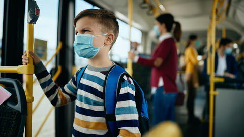 Kind mit Maske im Bus