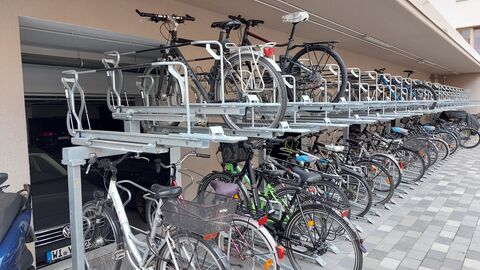 Mit dem Fahrrad in der Stadt unterwegs, weil es gute Infrastruktur gibt. Fahrräder in einer Fahrradabstellanlage