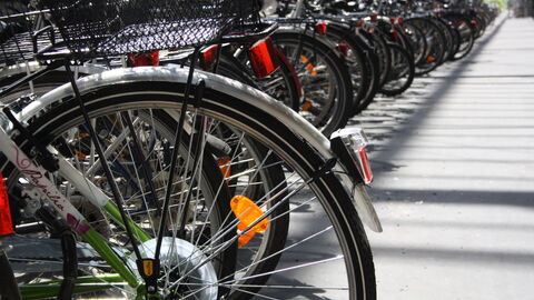 Mit dem Fahrrad in der Stadt unterwegs, weil es gute Infrastruktur gibt. Fahrräder in einer Fahrradabstellanlage