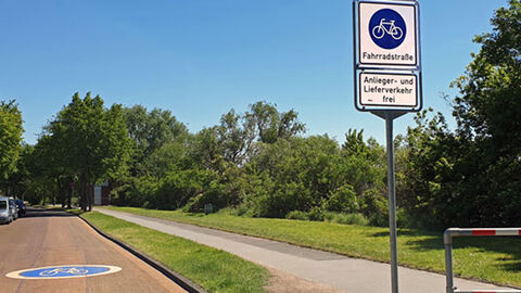 Fahrradstraße mit Schild und großem blauen Symbol auf der Fahrbahn