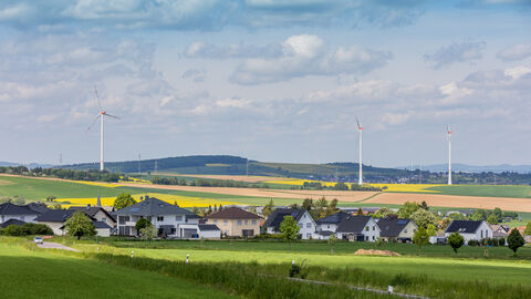 Wohngebiet mit Windrädern im Hintergrund