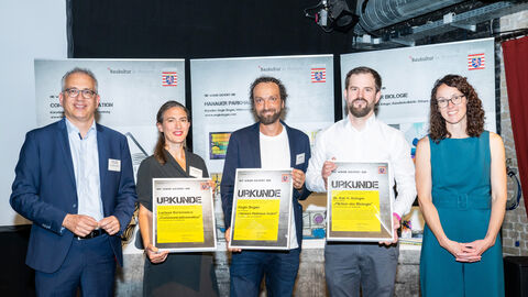 Tarek Al-Wazir und Angela Dorn mit den drei Preisträgern des Wettbewerbs "Alles nur Fassade"