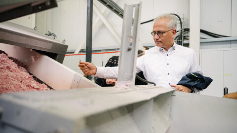Tarek Al-Wazir besucht Kunststoff-Recycler General Industries Deutschland. Es schaut sich den Recyclingprozess an.