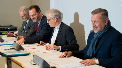 Verkehrsminister Tarek Al-Wazir bei der öffentlichen Unterzeichnung der Finanzierungsvereinbarungen mit den Geschäftsführern der drei Verkehrsverbünde Rhein-Main-Verkehrsverbund (RMV), Nordhessischer Verkehrsverbund (NVV) und Verkehrsverbund Rhein-Neckar (VRN)