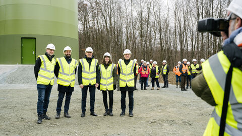 Besuch der Baustelle des Windparks Leun-Löhnberg Gruppenfoto Energieminister Al-Wazir mit anderen Leuten in gelber Jacke und mit Helm bei der Baustellenbesichtigung vor einem Windrad.
