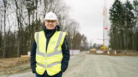 Besuch der Baustelle des Windparks Leun-Löhnberg Energieminister Al-Wazir in gelber Jacke und mit Helm bei der Baustellenbesichtigung vor einem Windrad.