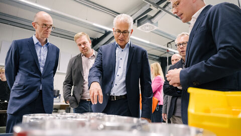 Besuch beim Elektromotorenhersteller Plettenberg Al Wazir vor einigen Teilen von Elektromotoren, weitere Personen erklären.