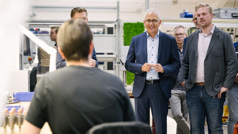 Al-Wazir unterhält sich mit einer Person, die ihm zugewandt am Schreibtisch sitzt.