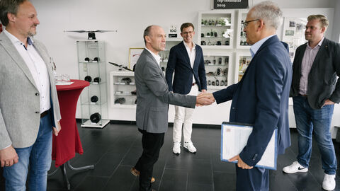 Al-Wazir wird bei der Firma Plettenberg durch mehrere Personen begrüßt, sie schütteln Hände.