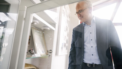 Al-Wazir schaut sich Teile in einem Glaskasten an.