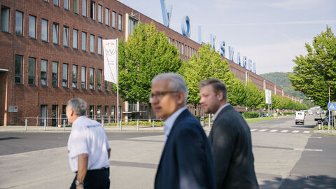 Al-Wazir mit zwei weiteren Personen vor dem VW Werk