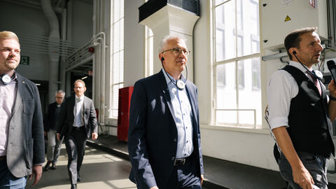 Eine Gruppe Personen um Wirtschaftsminister Al-Wazir bewegt sich durch das Werk