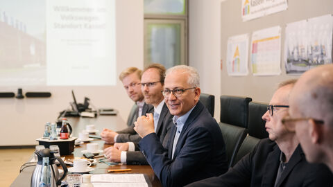 Besuch im Volkswagen Werk Kassel Wirtschaftsminister Al-Wazir an einem Tisch im Konferenzsaal mit mehreren Personen.