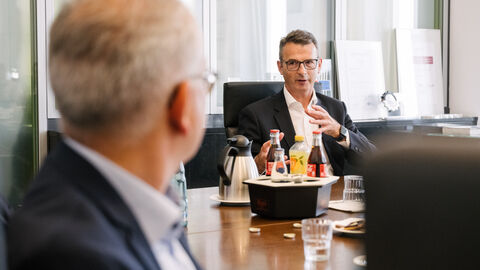 Besuch im Volkswagen Werk Kassel Wirtschaftsminister Al Wazir einem Mann am Konferenztisch zugewendet