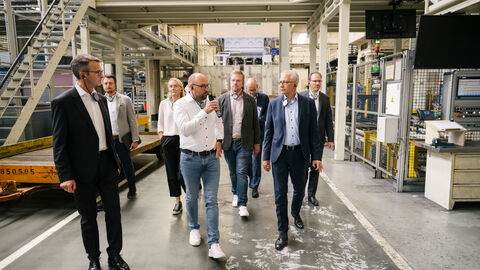 Eine Gruppe Personen um Wirtschaftsminister Al-Wazir bewegt sich durch das Werk