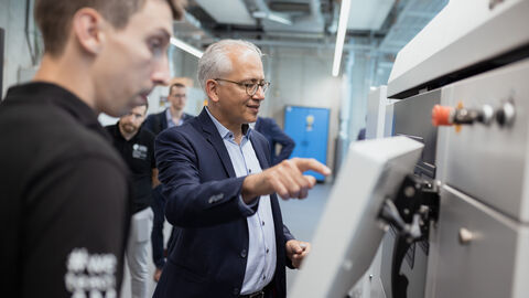 Wirtschaftsminister Al-Wazir an einem Gerät.