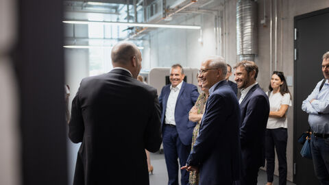 Eine Gruppe Personen um Wirtschaftsminister Al-Wazir steht in den Räumlichkeiten des AMC.