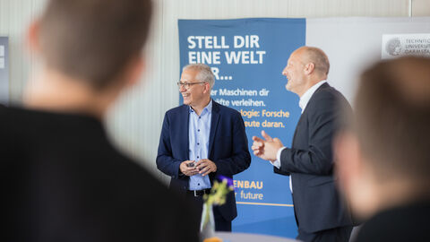 Minister Al-Wazir vor einem Informations-Aufsteller im Gespräch.