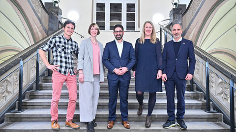 Fünf Personen stehen auf einer Treppe