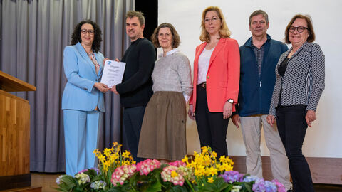 Sechs Personen stehen auf einer Bühne