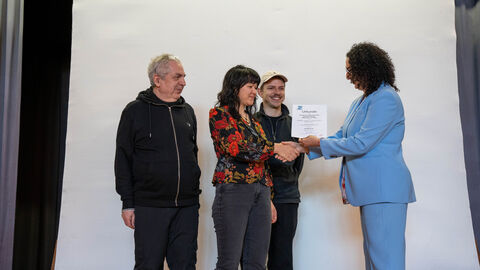 Vier Personen stehen auf einer Bühne