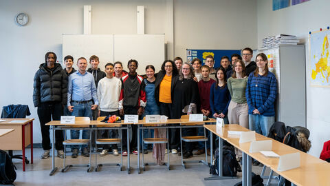 Eine Schülerklasse steht in einem Klassenraum