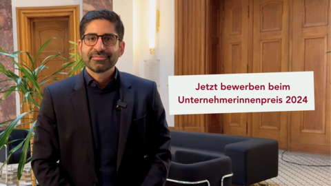 Ein Mann steht in einem Raum und sieht freundlich in die Kamera