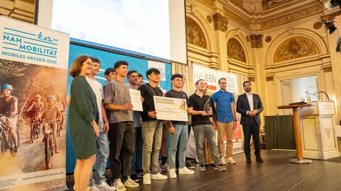 Auszeichnung im Wettbewerb Schulradeln Mehrere Personen stehen auf einer Bühne und halten einen Check in der Hand