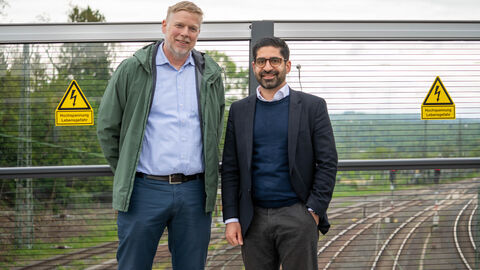 Zwei Männer stehen auf einer Brücke