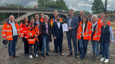 Bescheidübergabe an die Stadt Kassel  Mehrere Personen stehen auf einer Baustelle
