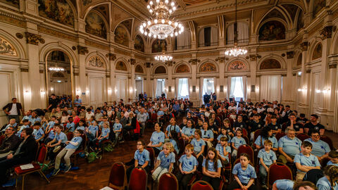 Blick in einen großen Sahl in dem mehrere Personen sitzen