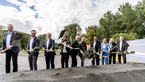 Mehrere Personen stechen mit einem Spaten in einen Erdhaufen